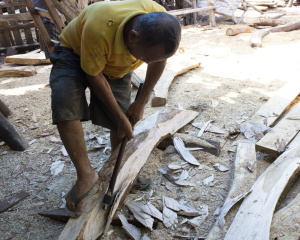 A worker shaping a frame with an axe in Tanah Beru. Photo: UNO/UI