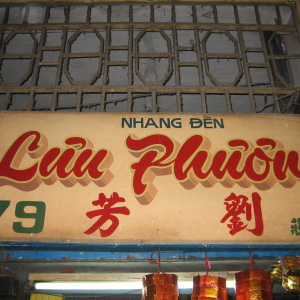 Signage from an establishment selling incense sticks with Chinese characters. Bundles of incense hang below the sign. (Photo: logicalthings, licensed under CC BY-NC 2.0.)