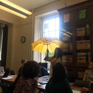 Yiluo Mose, collaborator for the EMKP Project "Dreams of yellow: Documenting the making and performance of Nuosu oil-cloth umbrellas", introducing herself and her project with an example of a Nousu oil-cloth umbrella. (Photo: Adriana Boloc)