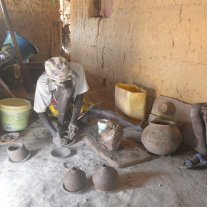 Ms Nhaguis crafting a ceramic vessel while observed by Felupe children (Photo: Bruno Pastre Máximo)