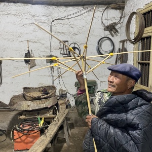 The local craftmaker Rila Moshi is displaying the skeleton for the yellow umbrella (Photo: Yongxiang Luo)