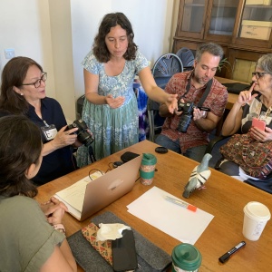 EMKP Project Curator Orly Orbach (center) speaking to EMKP Grantees Christine Habib, Renuka Gurung, Edson Materezio, and Renata Peters (left to right) about camera settings during a session on still photography at the 2023 EMKP Training. (Photo: Li-Xuan Teo)