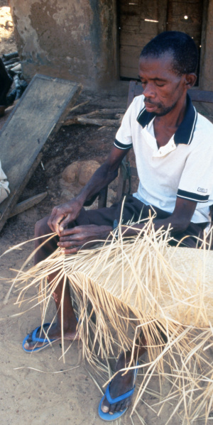 A man weaves a mat using locally sourced materials, Sabiye, 1994. (Photo: M. Dores Cruz)