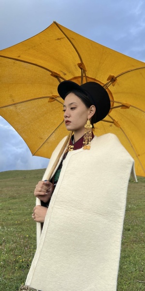 Nuosu woman with yellow umbrella in the mountains (Photo: Cigui Edi)