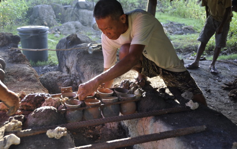 Salt maker (Mr. Florencio Bitoy) arranging pots on a stove in Alburquerque, Bohol, Philippines. Photo: Andrea Yankowski