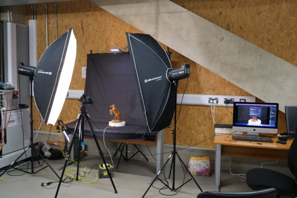 Professional set-up, utilising lights, a black backdrop and stand, an automatic turntable, a remote control, and a tripod.